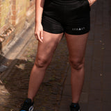 Women's black shorts with small white Legacy logo on leg.