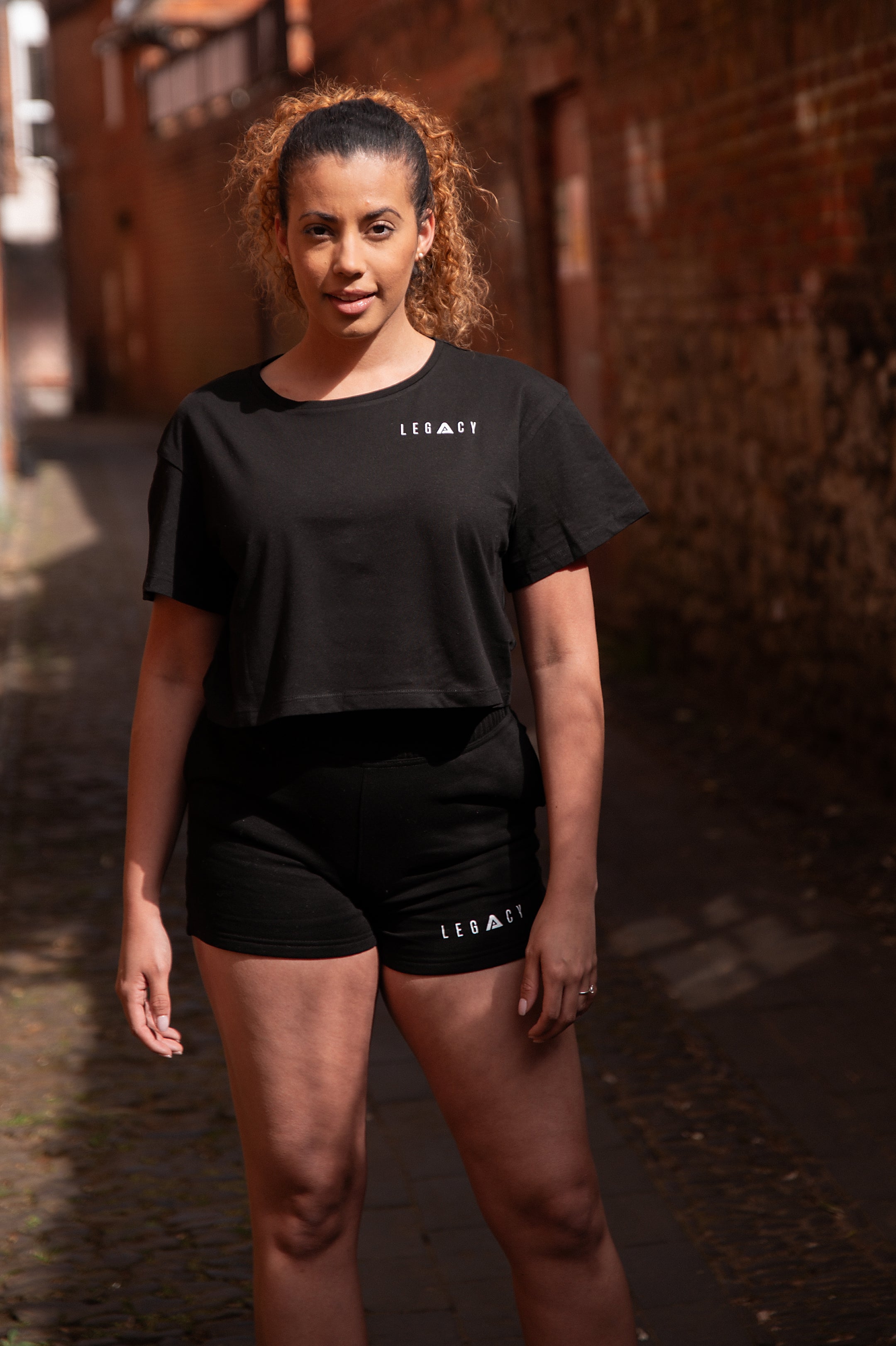 Women's black shorts with small white Legacy logo on leg.
