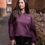 Women's burgundy oversized crop hoodie with tie waist and small white logo.