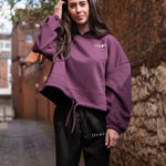 Women's burgundy oversized crop hoodie with tie waist and small white logo.