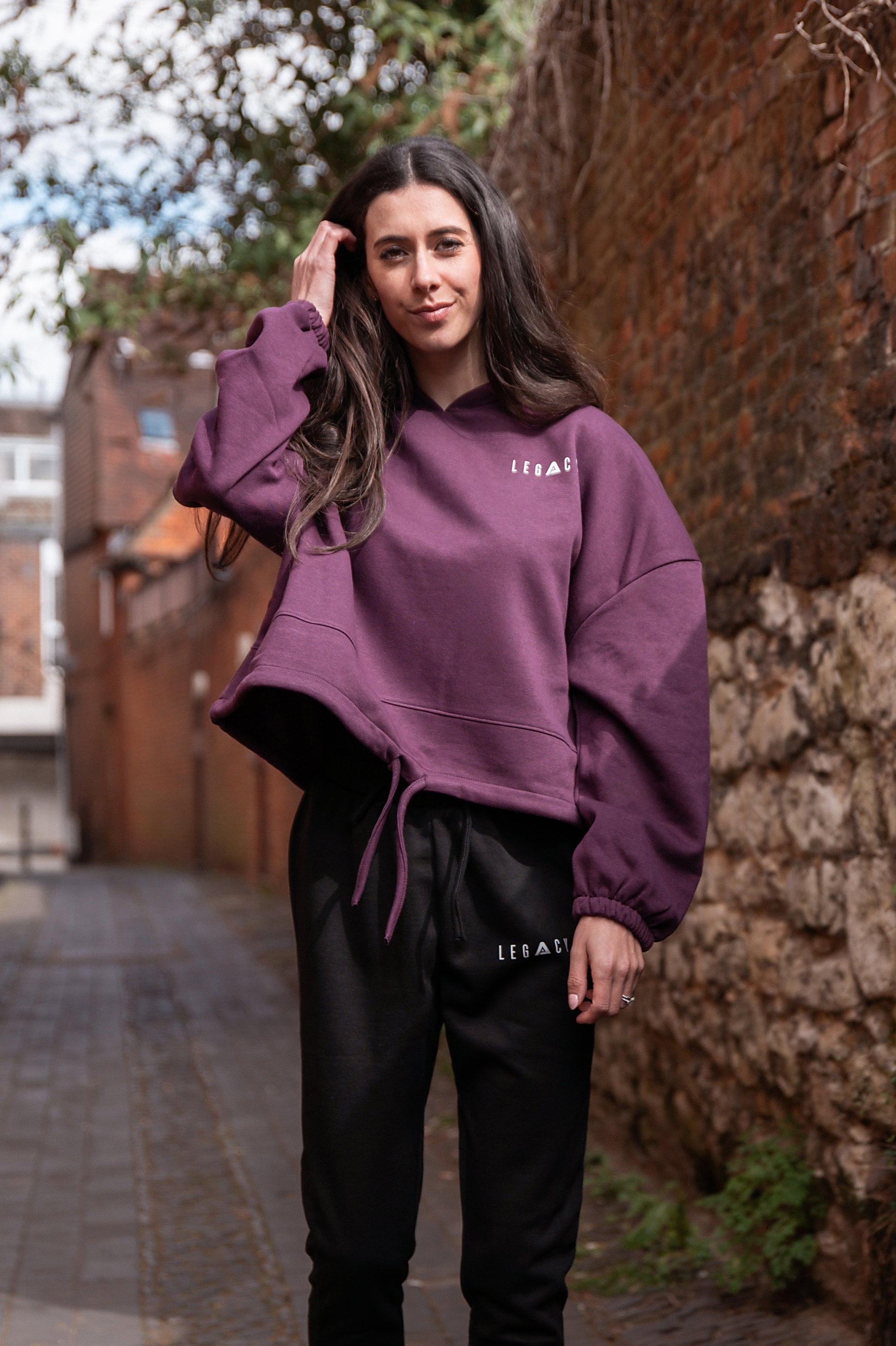 Women's burgundy oversized crop hoodie with tie waist and small white logo.