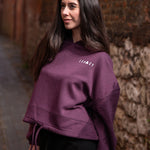 Women's burgundy oversized crop hoodie with tie waist and small white logo.