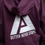 Back view of women's burgundy oversized crop hoodie with tie waist and white Better Never Stops logo.