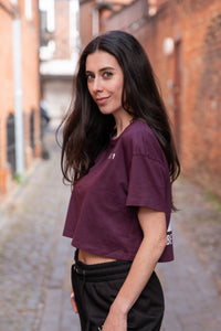 Women's burgundy crop t-shirt with white logo.