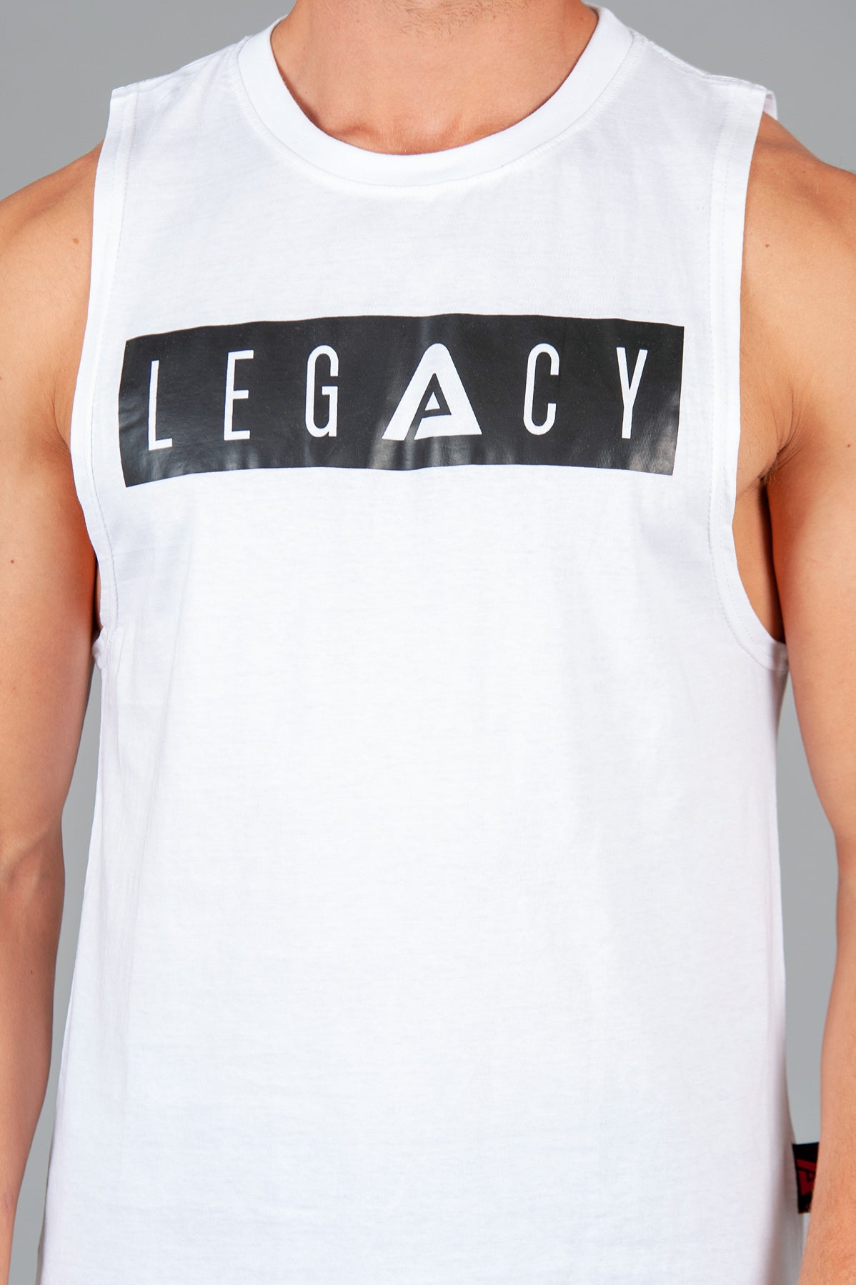 Men's white tank with black boxed Legacy logo across chest. 