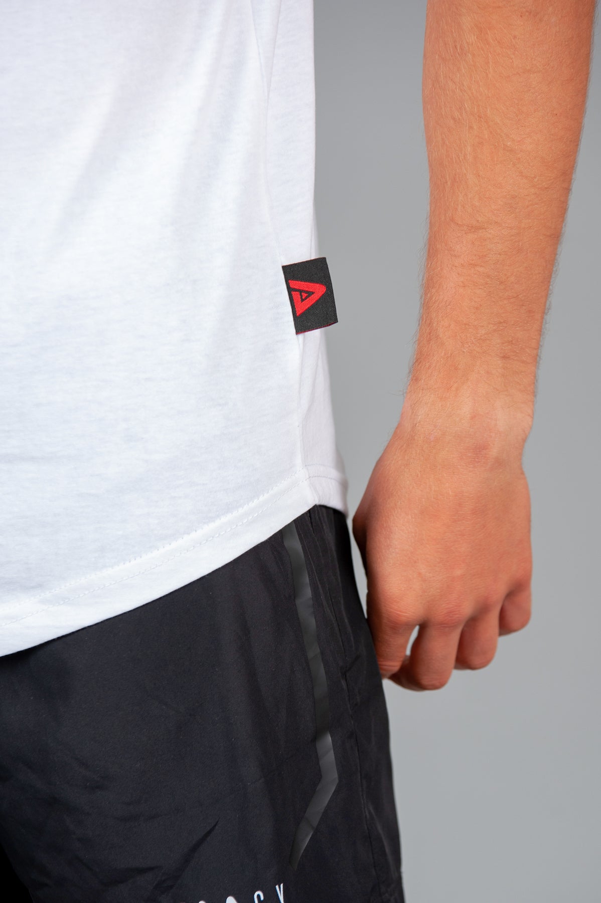 Close up of Legacy tag on men's white tank.