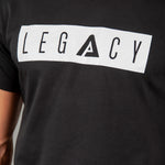 Close up of men's black t-shirt with white boxed Legacy logo across chest. 