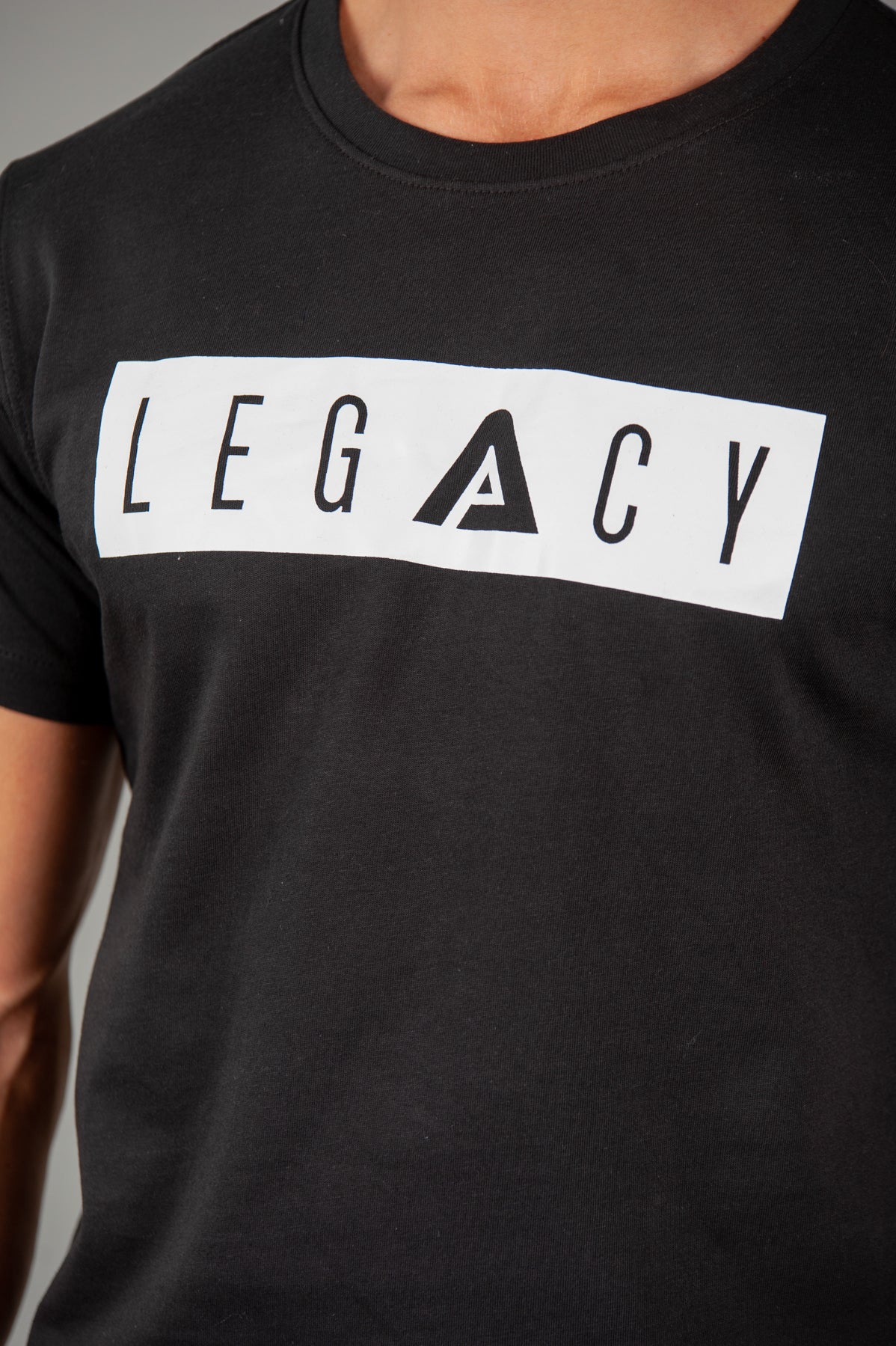 Close up of men's black t-shirt with white boxed Legacy logo across chest. 