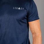 Close up of white logo on men's navy moisture wicking crewneck t-shirt.