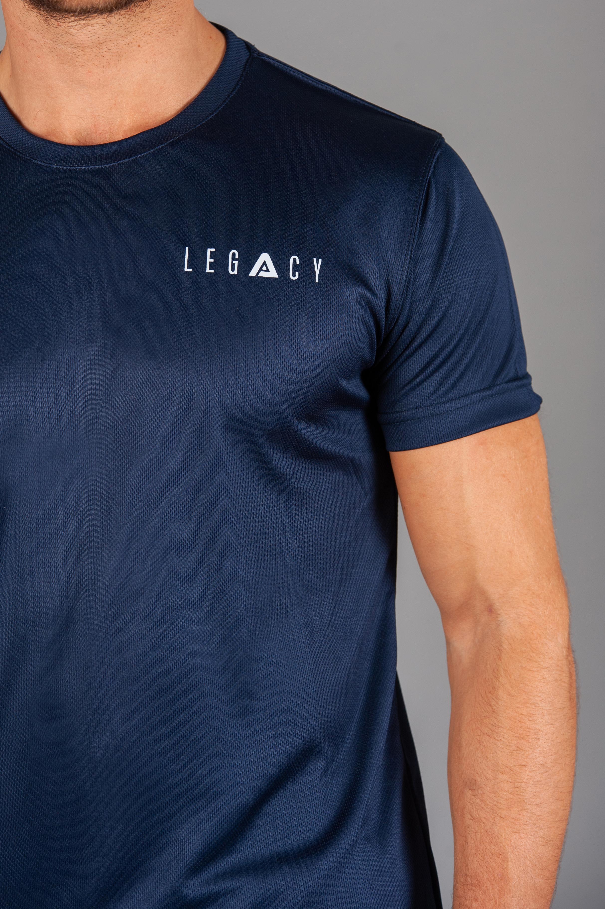 Close up of white logo on men's navy moisture wicking crewneck t-shirt.