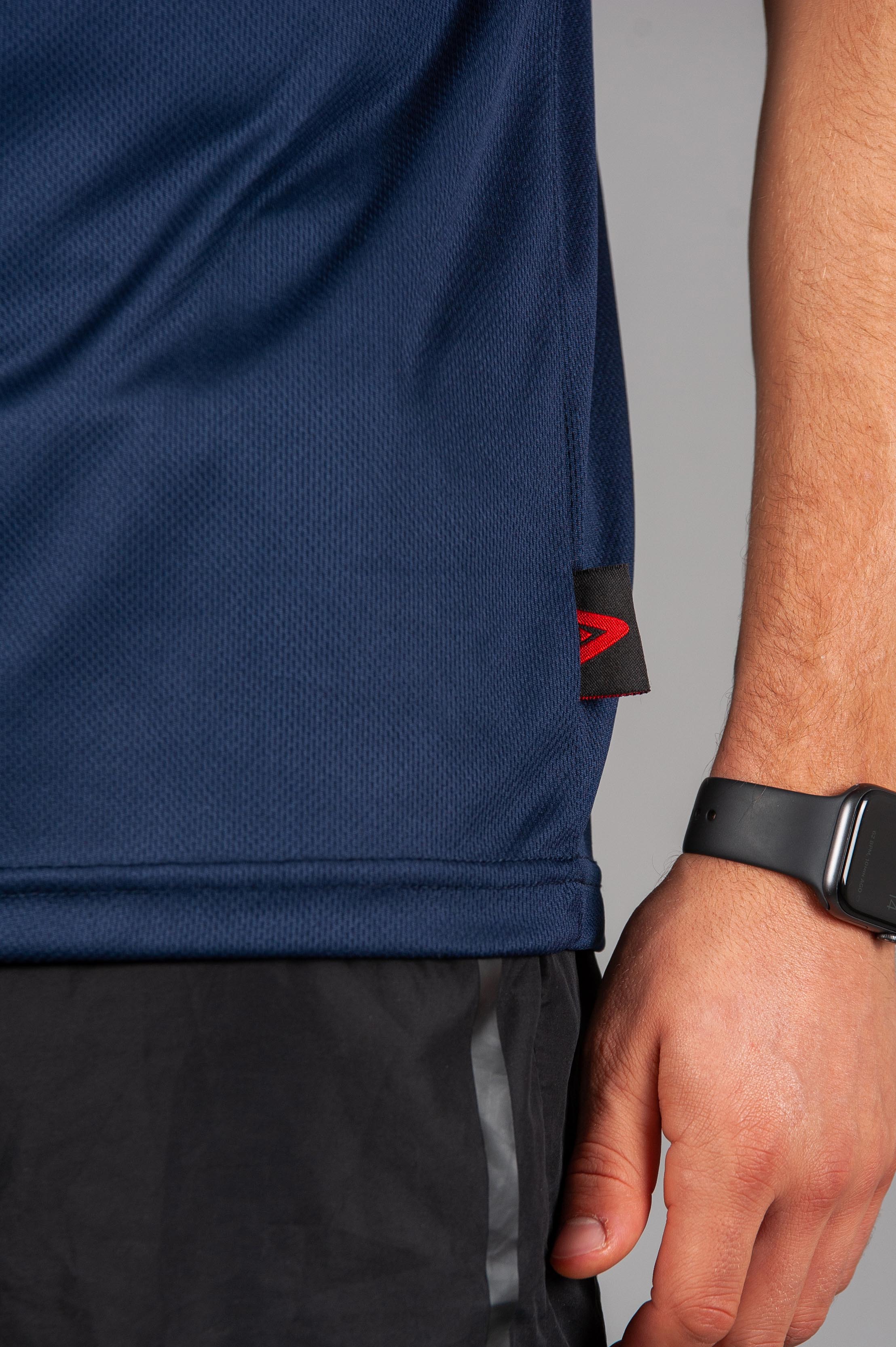 Close up of fabric on men's navy moisture wicking t-shirt.
