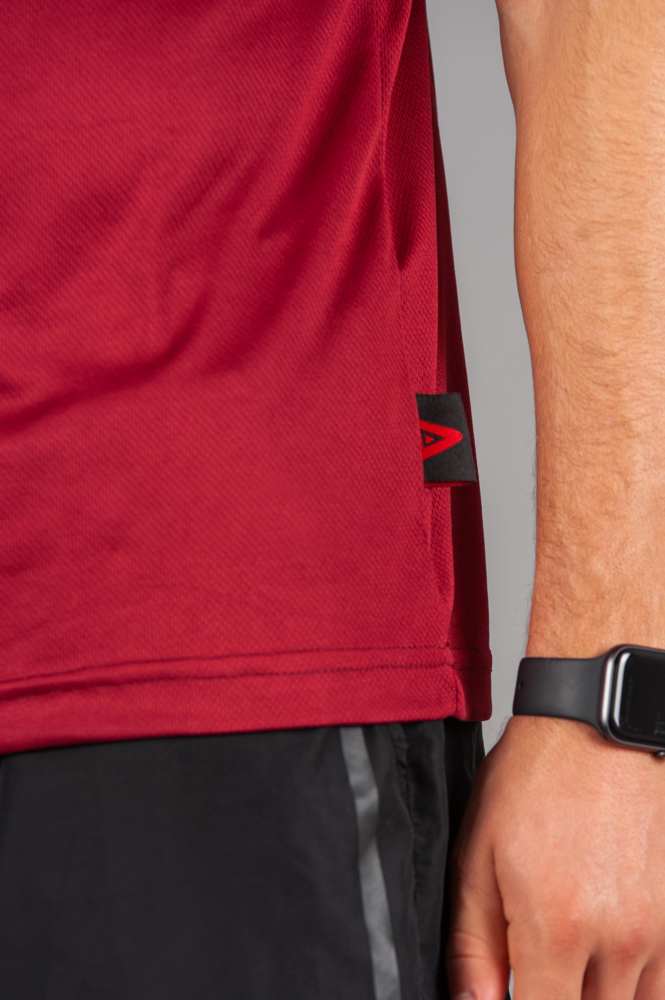Close up of men's burgundy moisture wicking crewneck t-shirt fabric. 