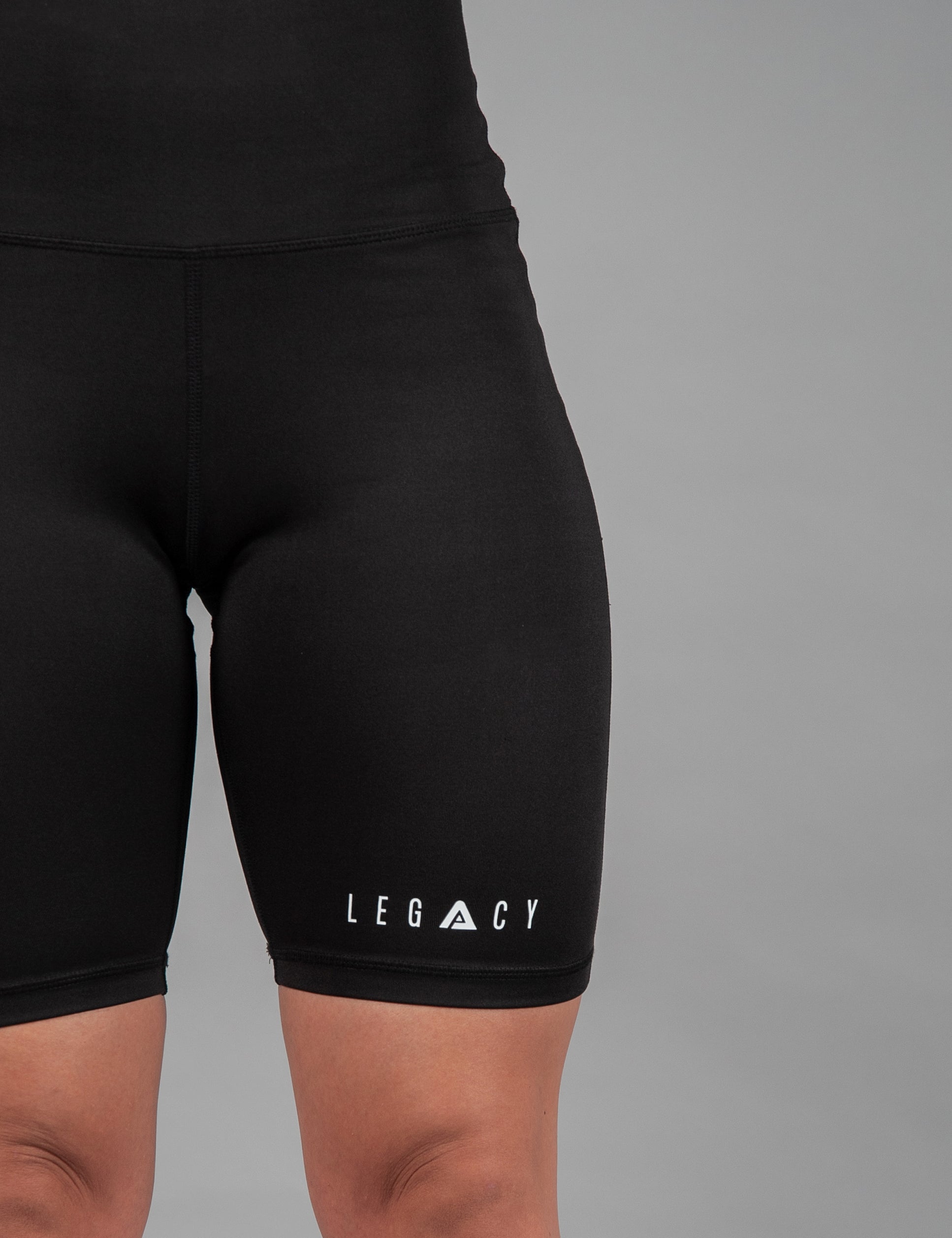 Women's black bike shorts with small white Legacy logo on the leg. 