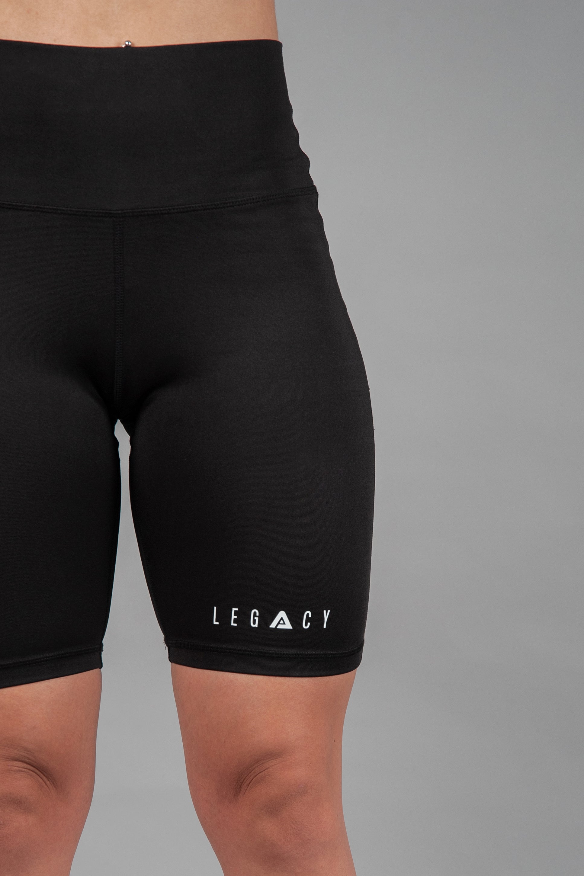 Women's black bike shorts with small white Legacy logo on the leg. 