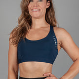 Women's navy sports bra with white Legacy logo on the side.