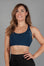 Women's navy sports bra with white Legacy logo on the side.