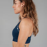 Women's navy sports bra with white Legacy logo on the side.