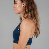 Women's navy sports bra with white Legacy logo on the side.