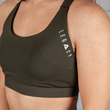Women's olive sports bra with white Legacy logo on the side.