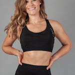 Women's black sports bra with white Legacy logo on the side.